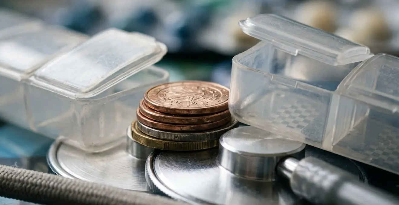 Vue macro de pièces de monnaie et objets symbolisant les dépenses de santé